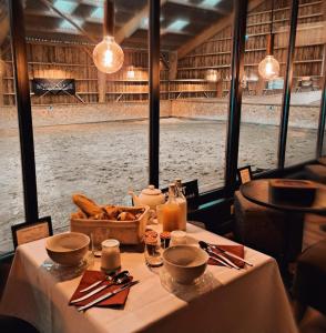 a table in a restaurant with a view of the snow at Manège de la Chapinière - DadaLoge tiny-house in Châteauvieux +78 photos