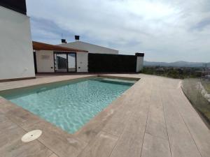 a swimming pool on the side of a house at Suite detallista y Piscina Vistas en azotea común in Murcia