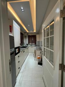 SagisaFive Palms One Bedroom Pent House Apartment的一间大厨房,配有白色的橱柜和一张桌子