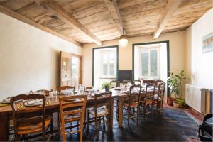 a large dining room with a long table and chairs at Les chambres de la ferme de chalas in Valgorge