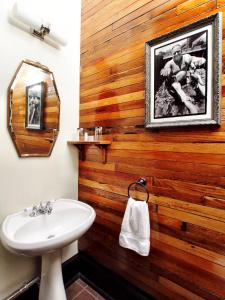 a bathroom with a wooden wall with a sink at Royal Street Inn & Bar in New Orleans