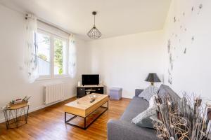 a living room with a couch and a coffee table at Maison Ker Morin La Gacilly in La Gacilly