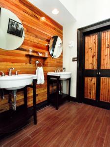 ein Badezimmer mit zwei Waschbecken und einer Holzwand in der Unterkunft Royal Street Inn & Bar in New Orleans
