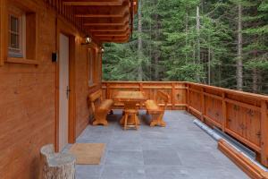 a porch of a cabin with a table and chairs at Luxury Villa TINKA in Zgornje Gorje