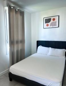 a bedroom with a bed with white sheets and a window at Studio in Lormont with Free Parking in Lormont