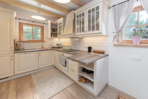 Una cocina con gabinetes blancos y encimera. en Luxury Villa TINKA, en Zgornje Gorje