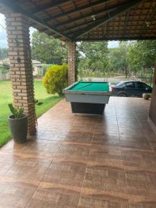 a covered patio with a pool table on it at Chácara Recanto Monjolinho in Planaltina