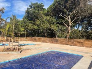 an empty swimming pool with a wooden fence and trees at Chácara Recanto Monjolinho in Planaltina