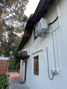 a building with a air conditioner on the side of it at Plotsklaps Self Catering Cottage in Tokai