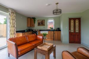 a living room with a couch and a table at Self-contained cosy one bedroom holiday barn in Cowbridge