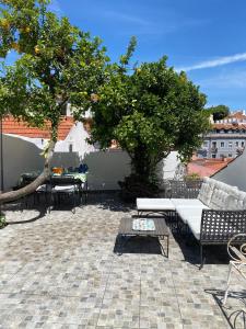 a patio with a couch and a table and a tree at Castelo Terrace in Lisbon