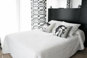 a bedroom with a white bed with pillows on it at Estudios Sierra De Francia in Béjar