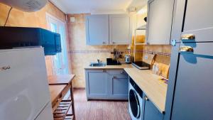 a kitchen with blue cabinets and a white refrigerator at Cozy Historical Andalusian 3BR House Peachy Stays in Mijas