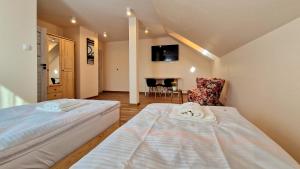 a room with two beds and a chair in it at Wisienka in Pstrągowa