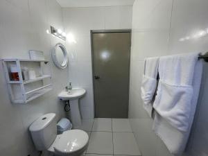 a white bathroom with a toilet and a sink at Viva Alto Vista! in Noord