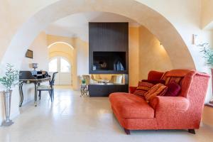 a living room with a red couch and a table at Villa Sun Rock - Ravdoucha in Kolymvari