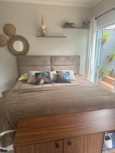 a large bed with a wooden headboard in a bedroom at CASA DE PRAIA OLONAN BEACH in Itanhaém