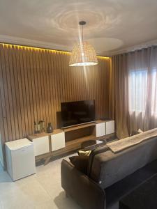 a living room with a couch and a flat screen tv at CASA DE PRAIA OLONAN BEACH in Itanhaém +42 photos