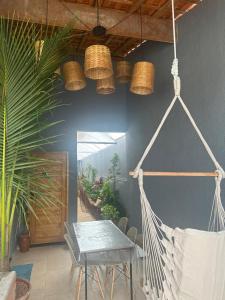 a hammock in a room with a table and chairs at CASA DE PRAIA OLONAN BEACH in Itanhaém