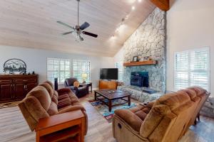 a living room with couches and a stone fireplace at Windwood Inn in Shaver Lake