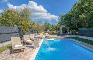 a swimming pool with chairs and a fountain at House Runjic w pool large garden and playground in Prgomet
