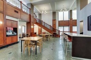 a dining room with tables and chairs and a staircase at Drury Inn & Suites Birmingham Lakeshore Drive in Birmingham +56 photos
