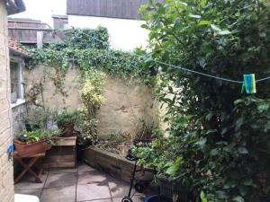 a garden with potted plants on a wall at Glastonbury 2-Bed House Sleeps 6 & Pet Friendly in Glastonbury