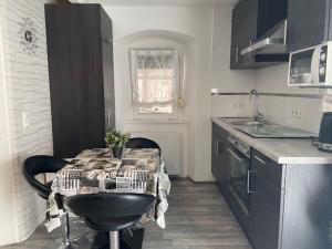 a kitchen with a table and a sink and a counter top at Appartement Manhattan in Blieskastel