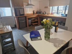 a kitchen with a table with a vase of flowers on it at The Annex in Tiverton