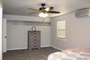 - une chambre avec un ventilateur de plafond et une commode dans l'établissement Cozy Corner Cottage, à Wellston