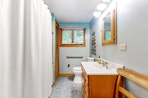a bathroom with a white toilet and a sink at Bomoseen Fever in Bomoseen +53 photos