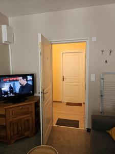una camera con televisore e porta di accesso a un corridoio di Charmant appartement centre ville proche thermes a La Bourboule