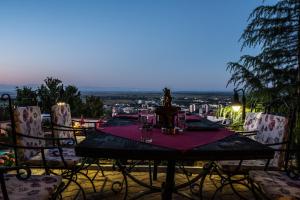 a table with wine glasses on top of a balcony at Chiflika Family Hotel in Asenovgrad