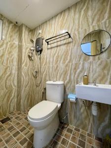 Un baño con inodoro, lavabo y espejo. en Hillview Cube w/Rooftop Pool, en Kuah