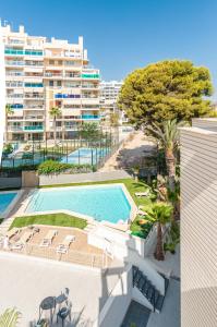an apartment with a swimming pool and a building at Myflats Campello Beach in El Campello