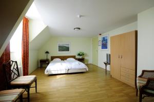 1 dormitorio con 1 cama grande con sábanas blancas en De Gouden Karper, en Rustenburg