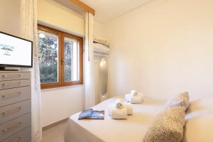 a bedroom with a bed with a television and towels at CA' DU GU' Free wifi - centrale in Carloforte