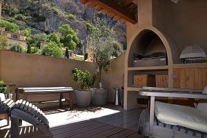 eine Terrasse mit einem Tisch, Bänken und einem Berg in der Unterkunft La Maison de Moustiers in Moustiers-Sainte-Marie