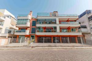 a tall building with a fence in front of it at Confortável Apartamento a Poucos Minutos da Praia in Bombas