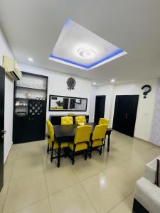 a dining room with a table and yellow chairs at Luxury Ikeja Apartment with 2 Bedrooms in Ikeja