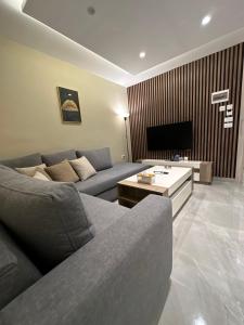 a living room with a couch and a tv at Chic Apartments For Rent ave0-8 in Umm Uthainah