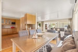 Una cocina y una sala de estar con mesa y sillas. en Luksuriøs enebolig ved Granåsen til Ski-VM 2025, en Trondheim