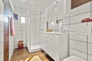 Un baño blanco con lavabo y espejo. en Luksuriøs enebolig ved Granåsen til Ski-VM 2025, en Trondheim 8 fotos más