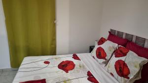 a bed with red and white sheets and pillows at Hibiscus et Miro in Ducos