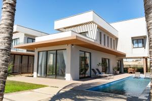 a house with a swimming pool in front of it at The Coral Beach Resort by Atlantica in Flecheiras