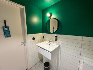 巴黎All Suites Appart Hôtel et Hôtel - Paris 13 - Porte d'Italie的带水槽和绿墙的浴室 更多27张照片