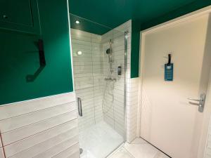 巴黎All Suites Appart Hôtel et Hôtel - Paris 13 - Porte d'Italie的浴室里有玻璃门的淋浴间