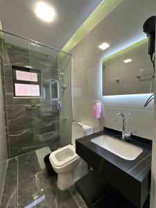 a bathroom with a sink and a toilet and a shower at Chic Apartments For Rent ave0-9 in Amman