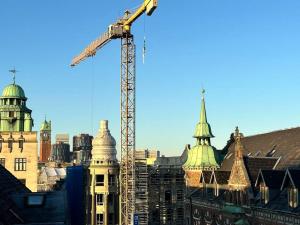 a construction crane and buildings in a city at Penthouse-Nordic-Citycenter-Balcony in Copenhagen
