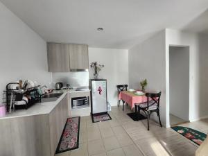 a kitchen with a table and a refrigerator at Centrio Phuket C3 in Ban Rangeng